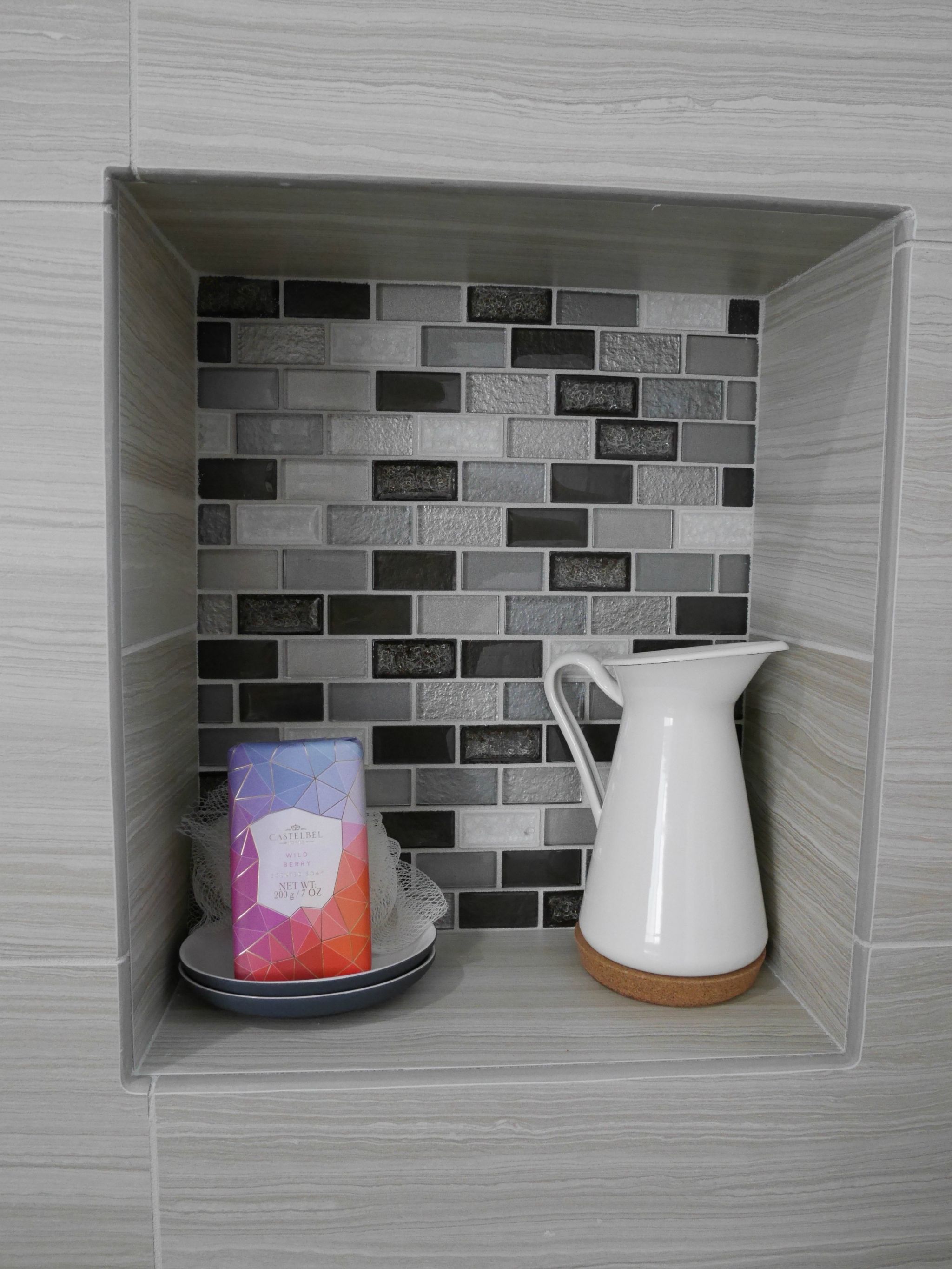 Recessed storage shelf with multi-colored grey, black and white tiles