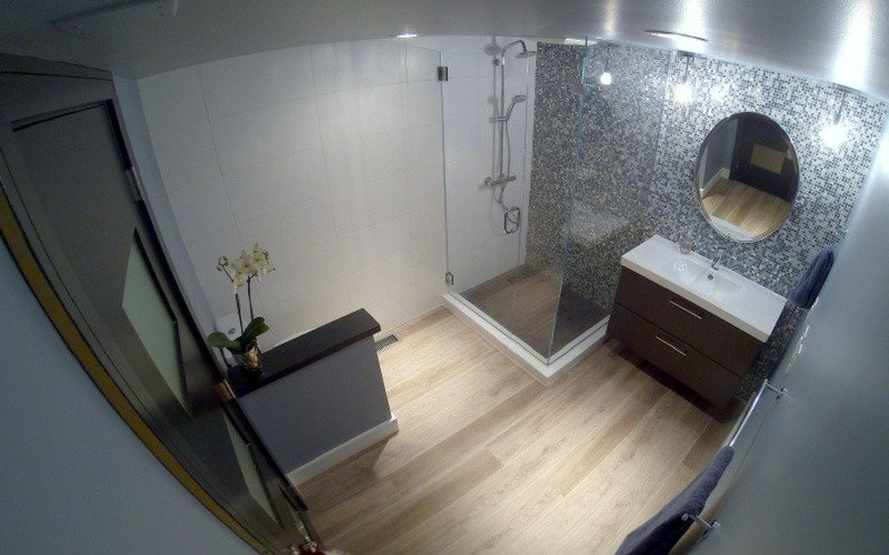 Banheiro com paredes cinza e piso de madeira clara