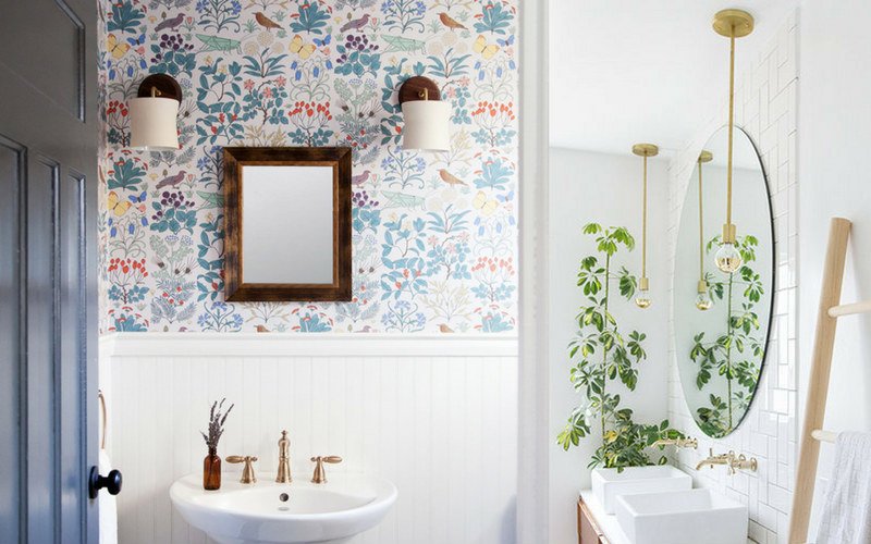 Bathroom with floral wall paper, white sink, and green plant in the corner