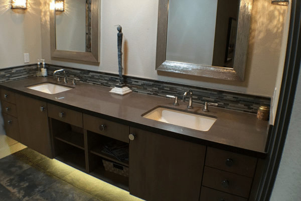 Two undermount sinks set in a dark brown marble vanity 