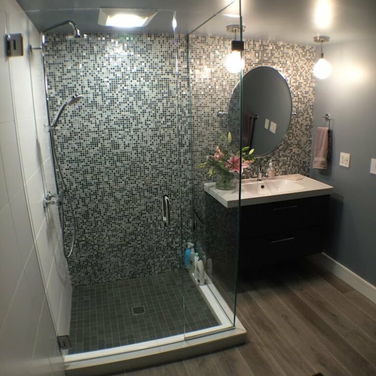 Remodeled tile bathroom with glass doors and new vanity