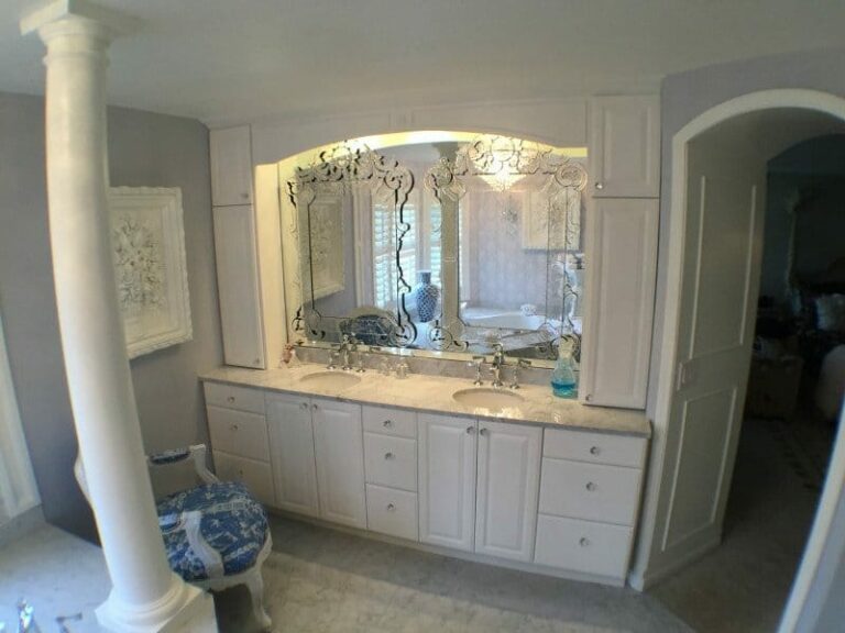 Remodeled bathroom vanity with white panels and quartz countertop