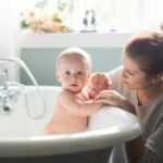 Baby in bath tub with mom