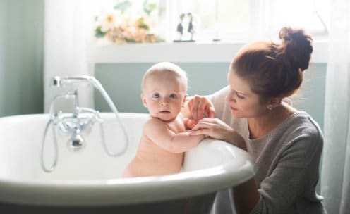 Baby in bath tub with mom